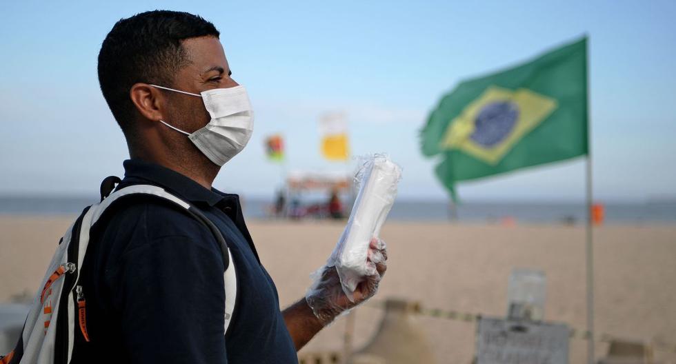 Un vendedor ambulante vende máscaras como medida preventiva contra la propagación del nuevo coronavirus en la playa de Copacabana en Río de Janeiro. (AFP).