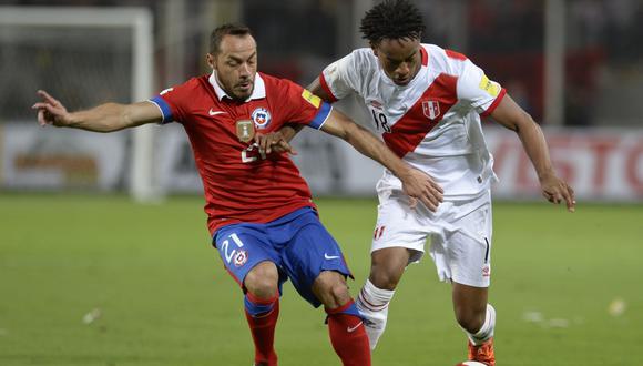 Marcelo Díaz y André Carrillo disputan el balón en el Estadio Nacional de Lima por las Eliminatorias. (AFP)