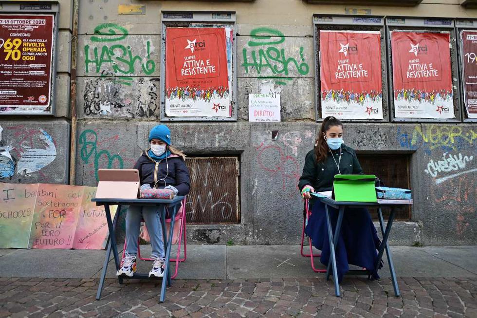Imagen de Anita Iacovelli (izquierda) sentada frente a la escuela Italo Calvino en Turín (Italia). (AFP / Miguel MEDINA).