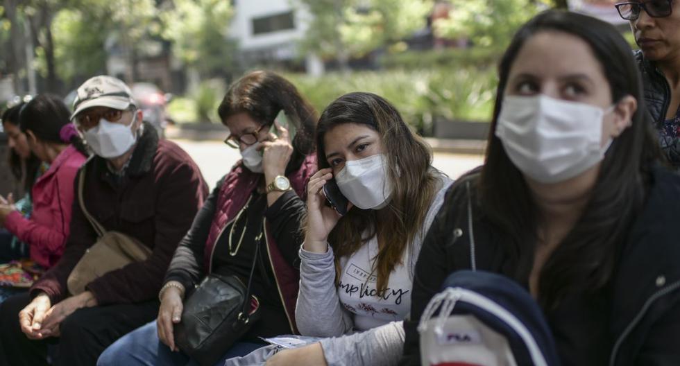 Ciudadanos peruanos usan máscaras faciales para evitar la propagación del nuevo coronoavirus COVID-19. (Pedro Pardo / AFP).