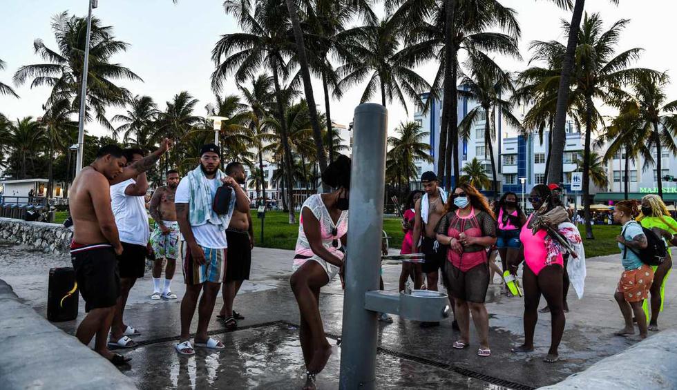 Una mujer se enjuaga los pies mientras otros esperan en Miami Beach, Florida. (AFP / CHANDAN KHANNA).
