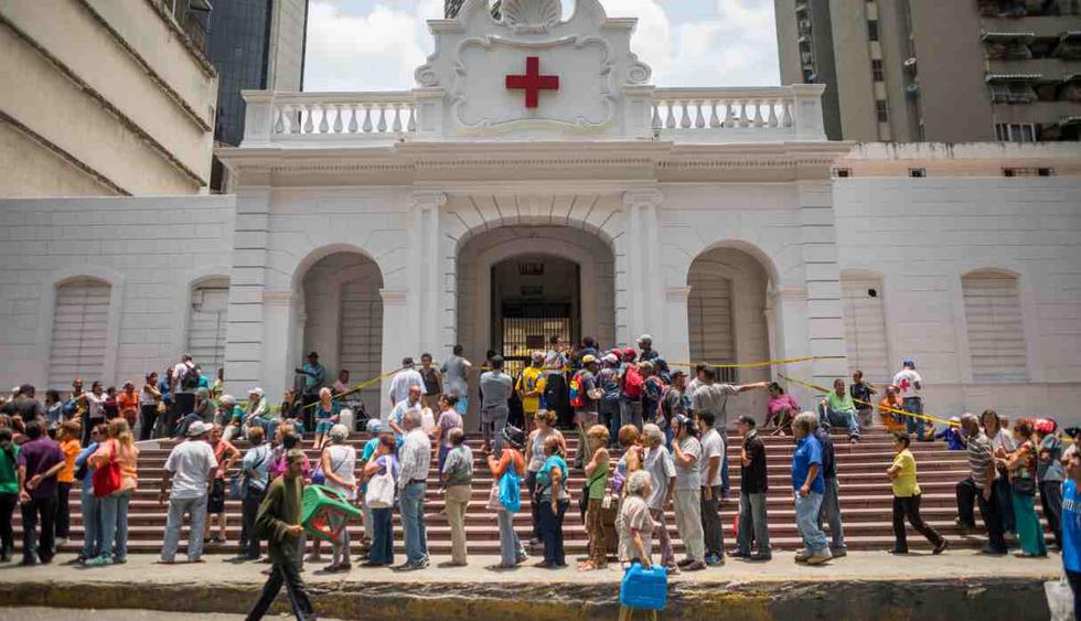 Decenas de personas asisten al hospital Carlos J Bello de la Cruz Roja para recibir el kit de agua potable que forma parte de la ayuda humanitaria este jueves, en Caracas. (Foto: AFP)