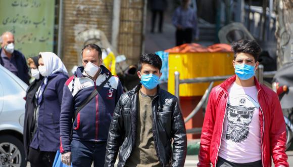 Iraníes usan máscaras protectoras contra el nuevo coronavirus mientras caminan por una calle en la capital Teherán. (Foto: AFP/Atta Kenare)