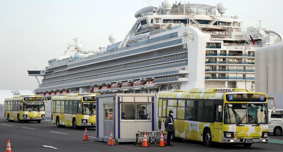 Imagen de varios autobuses saliendo del puerto de la ciudad de Yokohama en Japón. En la parte posterior se observa el crucero Diamond Princess. (EFE).