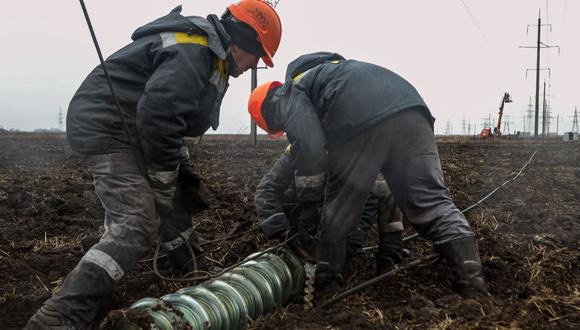 Los trabajadores reparan las líneas eléctricas de alto voltaje cortadas por los recientes ataques con misiles cerca de Odessa el 7 de diciembre de 2022, en medio de la invasión rusa de Ucrania. (Foto de OLEKSANDR GIMANOV / AFP)