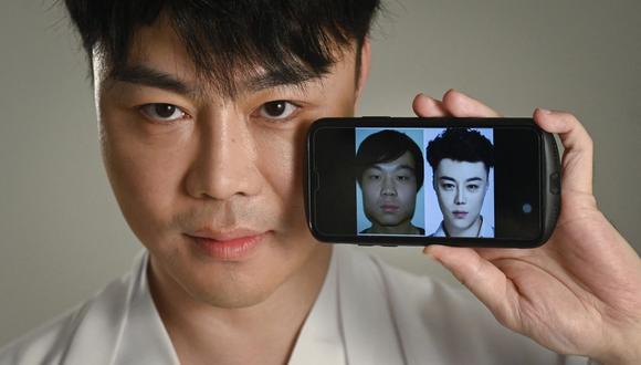 Esta imagen tomada el 20 de julio de 2021 muestra al actor chino Nai Wen mostrando fotos de sí mismo antes y después de una cirugía estética, en un estudio fotográfico en Beijing. (WANG ZHAO / AFP).
