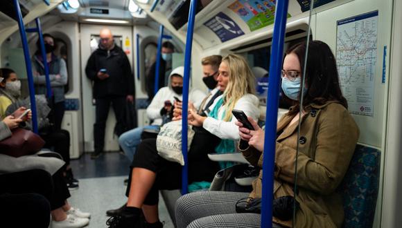Los viajeros, la mayoría con máscaras debido a la pandemia de coronavirus, viajan en un tren subterráneo de Londres en el centro de dicha ciudad. (Tolga Akmen / AFP)