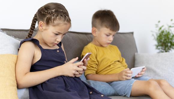 Niños mirando sus celulares.