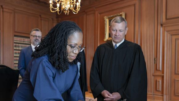 El presidente del Tribunal Supremo, John G. Roberts, Jr., observa cómo el juez Ketanji Brown Jackson firma el juramento del cargo en la sala de conferencias de los jueces del Tribunal Supremo en Washington, DC, en junio. 30 de enero de 2022. (Foto: Handout/US Supreme Court/AFP)