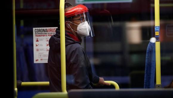Un hombre parado en un metro con su mascarilla y máscara facial. (Foto: EFE/Mariscal).