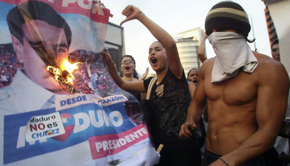 Opositores a Nicolás Maduro quemaron sus carteles en Caracas. (AFP)