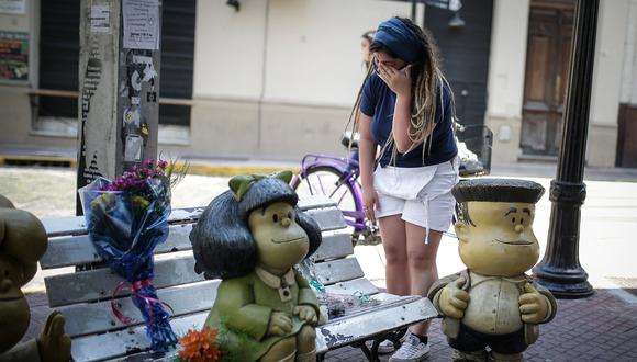 Una mujer llora hoy mientras le deja flores a la estatua de Mafalda tras el fallecimiento de su creador Quino, en Buenos Aires (Argentina). (Foto: EFE/JUAN IGNACIO RONCORONI)