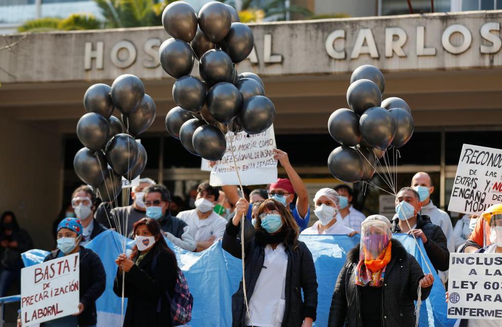 Trabajadores de la salud del Hospital Durand sostienen globos durante un minuto de silencio por los trabajadores de la salud fallecidos por COVID-19. (Reuters/Agustin Marcarian).