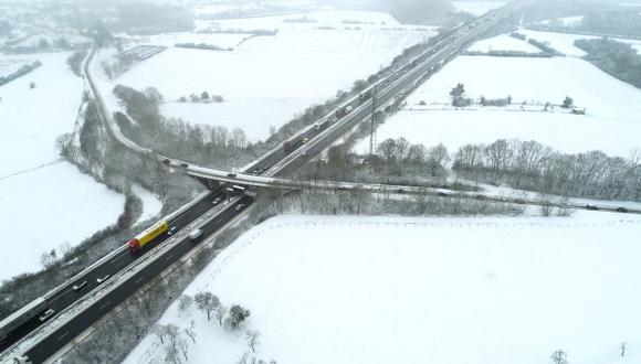 Esta vista aérea muestra los automóviles que circulan por la autopista y una carretera secundaria cerca de la frontera entre Francia y Luxemburgo después de la nevada. (Foto: AFP)