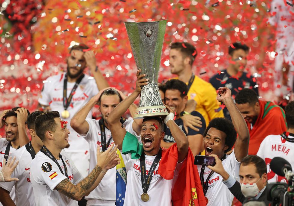 Sevilla's Brazilian midfielder Fernando (C) holds the trophy as Sevilla's players celebrate  after winning the UEFA Europa League final football match Sevilla v Inter Milan on August 21, 2020, in Cologne, western Germany. (Photo by Lars Baron / POOL / AFP)