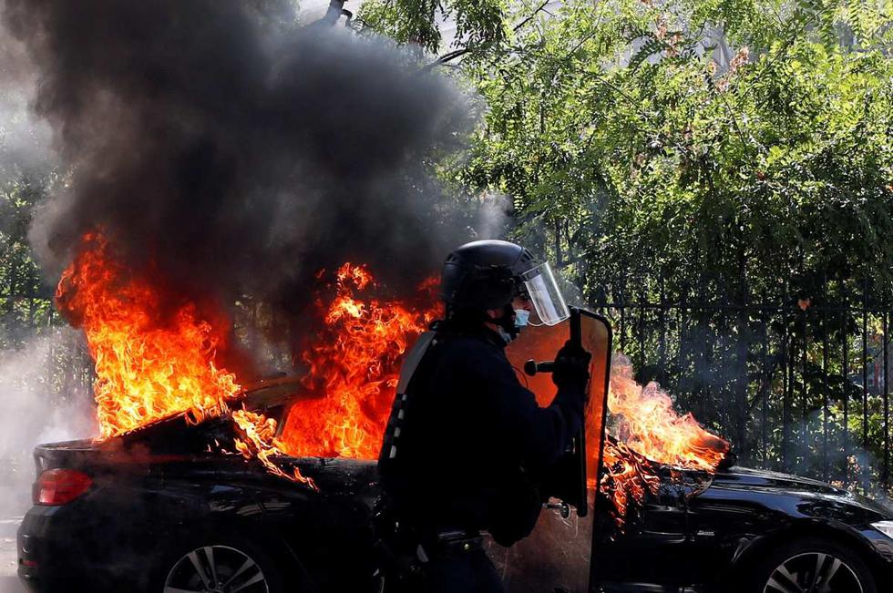 Un oficial de la policía antidisturbios pasa junto a un automóvil en llamas durante una manifestación de los chalecos amarillos en París, Francia. (REUTERS/Gonzalo Fuentes).