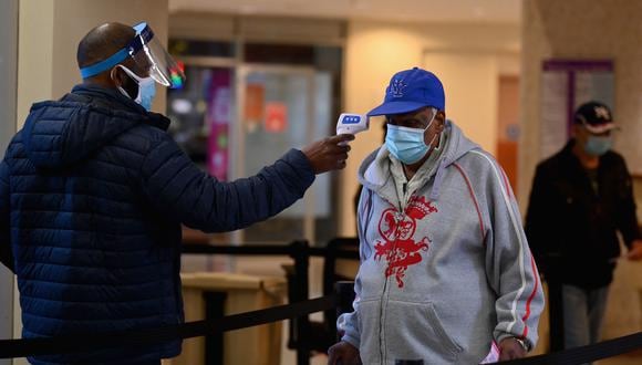 Un miembro del personal verifica la temperatura de un visitante en el Centro Médico y de Salud Mental Woodhull en la ciudad de Nueva York. (Foto: Angela Weiss / AFP)