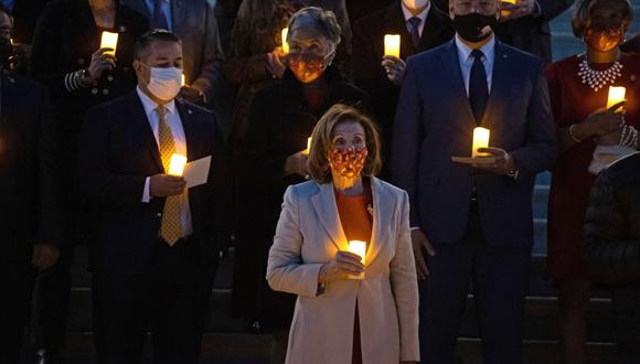 La presidenta de la Cámara de Representantes de Estados Unidos, Nancy Pelosi (C), el líder de la mayoría del Senado, Chuck Schumer (R) y el líder republicano de la Cámara, Kevin McCarthy (L), sostienen velas eléctricas mientras participan en una vigilia en memoria de las 800.000 personas que han muerto de Covid-19 en el EE.UU., en Washington, DC el 14 de diciembre de 2021. (Foto: ROBERTO SCHMIDT / AFP)