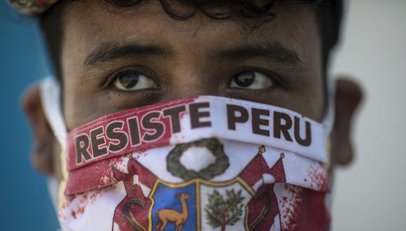 John Sanchez, que usa una máscara facial con un mensaje que dice "Resiste Perú", espera en la fila para hacerse la prueba de COVID-19 en el Hospital Almenara en Lima. (Foto AP / Rodrigo Abd).