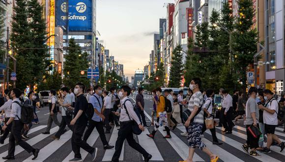 La gente camina por la calle mientras se mantiene el estado de emergencia por el coronavirus durante los Juegos Olímpicos de Tokio 2020 en Akihabara, distrito de Tokio, el 4 de agosto de 2021. (Foto de Yuki IWAMURA / AFP)
