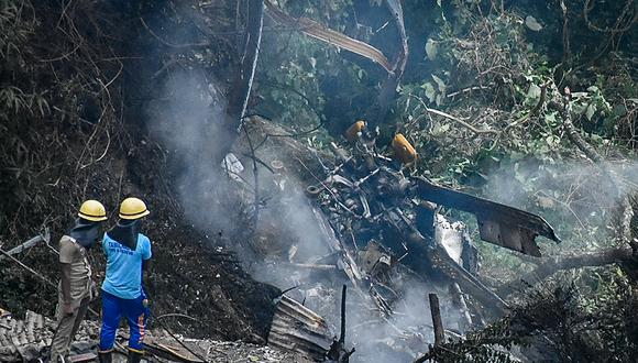 Los bomberos y los trabajadores de rescate se paran junto a los escombros del lugar del accidente de un helicóptero IAF Mi-17V5 en Coonoor, Tamil Nadu, el 8 de diciembre de 2021. (Foto: AFP)