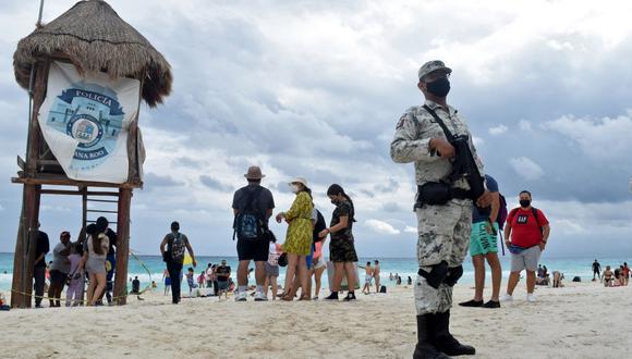 El 5 de noviembre, un comando de sicarios de un grupo narcotraficante irrumpió en la playa de Puerto Morelos, un centro turístico situado al sur de Cancún, y abrió fuego frente a los hoteles de lujo, ejecutando a dos narcotraficantes de una banda rival. Este dramático ataque a tiros obligó a los turistas a resguardarse. (Foto: Elizabeth RUIZ / AFP)