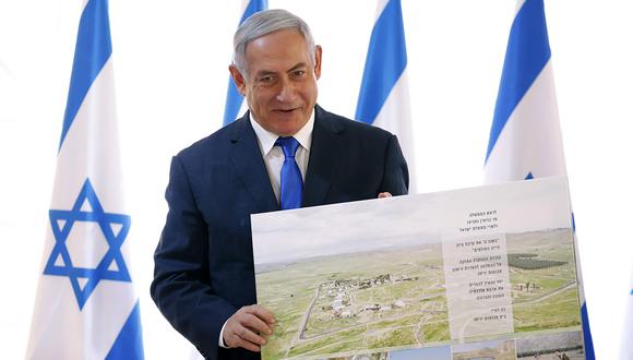 Benjamin Netanyahu sostiene pancarta que le regalaron los residentes israelíes, al comienzo de una reunión del gabinete en el Valle del Jordán, en Cisjordania. (Foto: EFE)