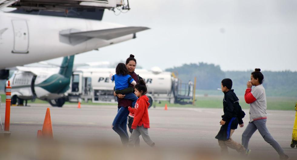 Un grupo de migrantes hondureños que hacía parte de la caravana rumbo a EE.UU. llega en un avión de la policía mexicana este miércoles al aeropuerto Ramón Villeda Morales, cerca de San Pedro Sula (Honduras). (Foto: EFE)