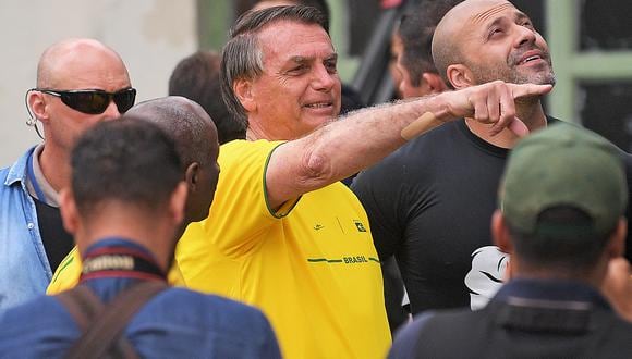 El presidente brasileño y candidato a la reelección, Jair Bolsonaro (C), se va con el político Daniel Silveira (D) después de votar durante las elecciones legislativas y presidenciales, en Río de Janeiro, Brasil, el 2 de octubre de 2022. (Foto de CARL DE SOUZA / AFP)