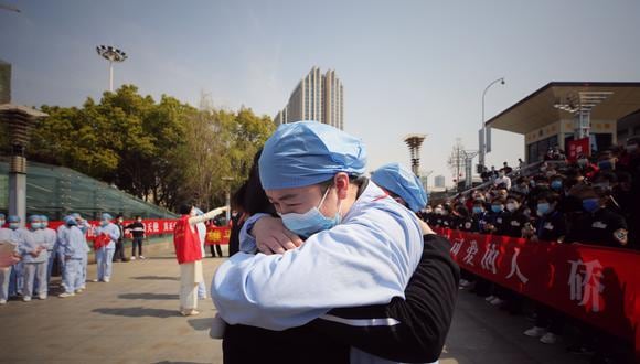 Trabajadores sanitarios que responden al COVID-19 se abrazan en Wuhan.  (Foto: STR / AFP) / China OUT