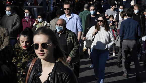 Personas, algunas con mascarillas, caminan por una calle mientras disfrutan de un día en Barcelona. (Foto: Pau BARRENA / AFP)
