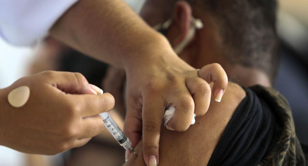 Un indigente es inoculado con la vacuna CoronaVac contra el COVID-19 durante una campaña de vacunación para personas en las calles de Sao Paulo, Brasil, el 30 de marzo de 2021. (Miguel SCHINCARIOL / AFP).
