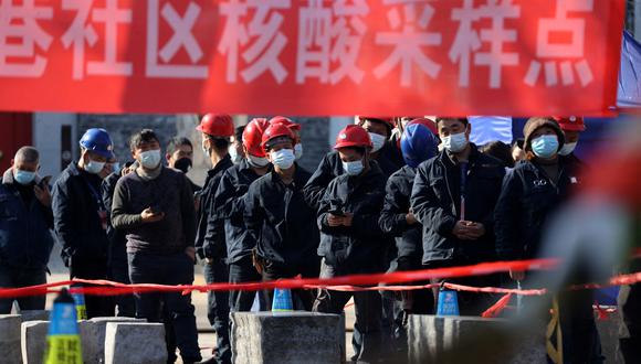Los trabajadores de la construcción hacen fila para hacerse la prueba del coronavirus  en Xi'an, en la provincia norteña de Shaanxi, en China, el 21 de diciembre de 2021. (Foto: AFP)