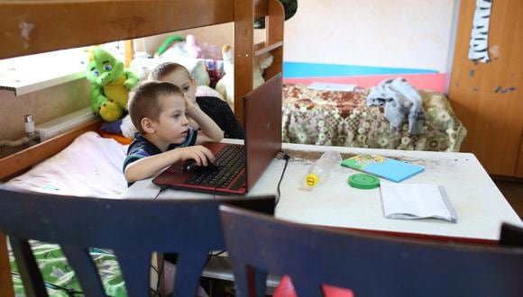 Dos niños se sientan frente a una computadora en su apartamento de una habitación en Mariupol el 3 de marzo de 2019. (Foto: ALEKSEY FILIPPOV / AFP)