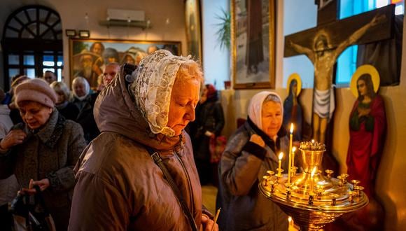 Fieles rezan durante la Misa de Navidad en la Catedral de la Ascensión del Señor en Kherson, en el sur de Ucrania, el 25 de diciembre de 2022, en medio de la invasión rusa de Ucrania. (Foto de Dimitar DILKOFF / AFP)