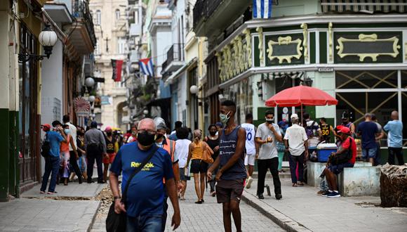 Cubanos con mascarillas caminan por una calle de La Habana. (Foto: YAMIL LAGE / AFP)