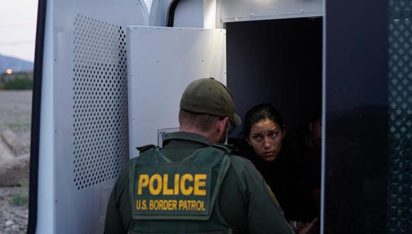 En esta foto del 22 de julio de 2021, una mujer que fue detenida cruzando la frontera entre Estados Unidos y México, habla con un agente de la Patrulla Fronteriza. (Foto de PAUL RATJE / AFP).