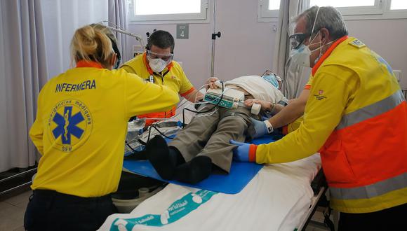 Trabajadores sanitarios de los Servicios Médicos de Emergencia de Cataluña (SEM) atienden a un paciente en el centro sanitario de Sant Felix en Sabadell. (Foto: AFP/Pau Barrena)