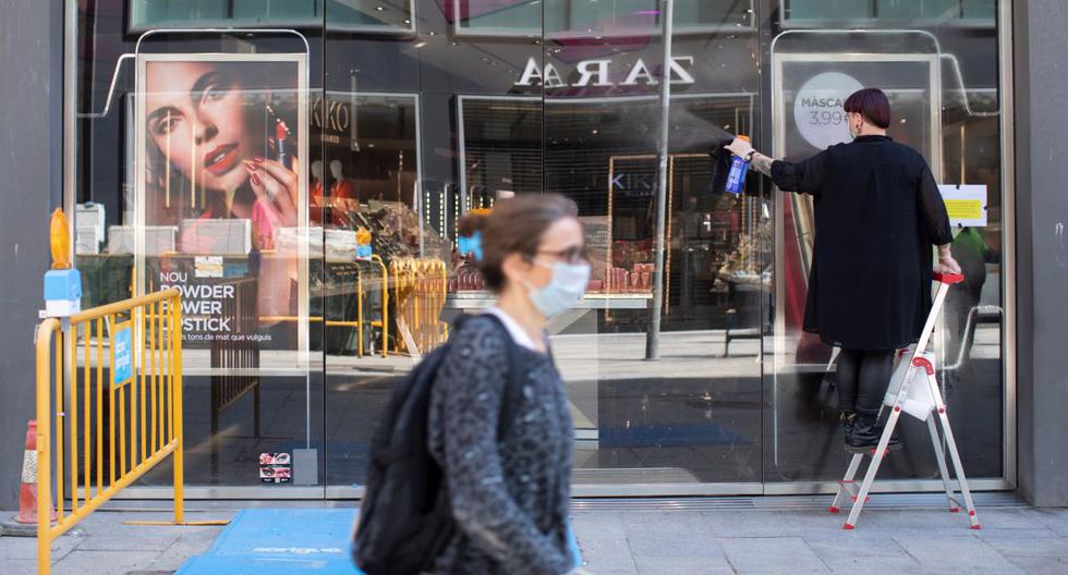 Una mujer camina portando una mascarilla en una popular calle comercial de Barcelona, en España. (Archivo/EFE/Marta Pérez).