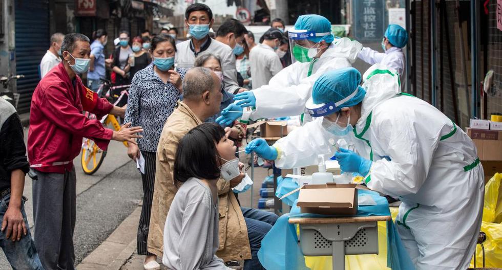 Trabajadores médicos toman muestras de hisopos de residentes para analizar el coronavirus (COVID-19) en una calle de Wuhan (China). Imagen de archivo del 15 de mayo de 2020. (AFP / STR).