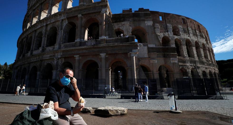 Un hombre con una mascarilla protectora se sienta cerca del Coliseo en Roma (Italia), el 8 de octubre de 2020. (REUTERS/Guglielmo Mangiapane).