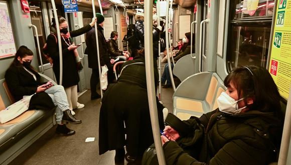 Los viajeros con máscaras protectoras se sientan en una de las líneas de metro de Milán el 3 de enero de 2022. (Foto: Miguel MEDINA / AFP)