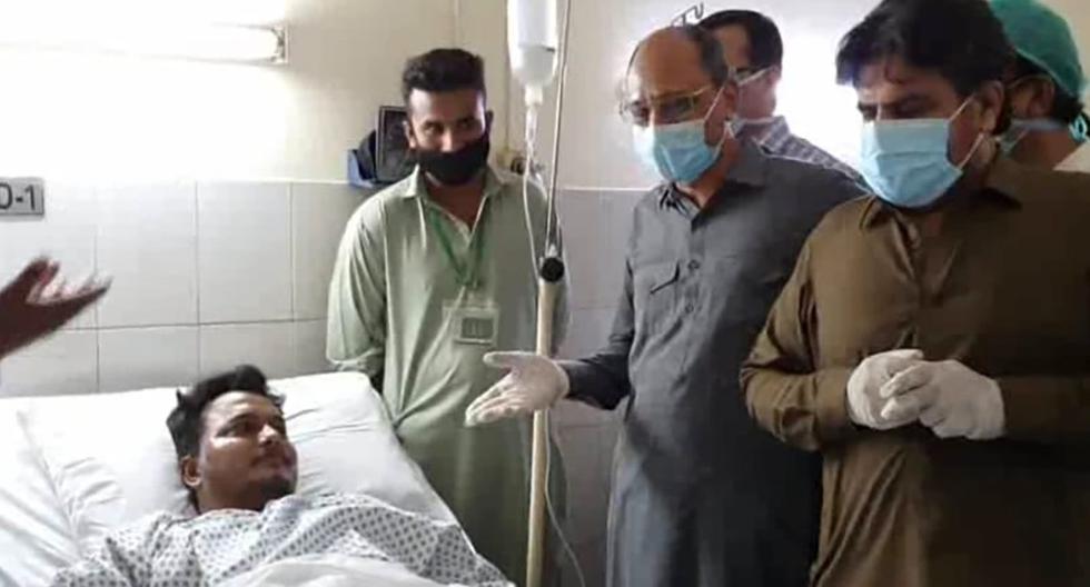 El ministro provincial de Sindh (Pakistán), Saeed Ghani (segundo desde la derecha) se encuentra con Mohamad Zubair, uno de los dos supervivientes del accidente de avión. (Departamento de Información de Prensa de Sindh/AP).