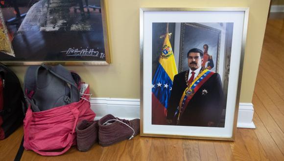 Una fotografía del líder venezolano Nicolas Maduro se sienta en el piso mientras los manifestantes, incluidos los del grupo Código Rosa, ocupan la Embajada de Venezuela en Washington. (Foto: AFP)