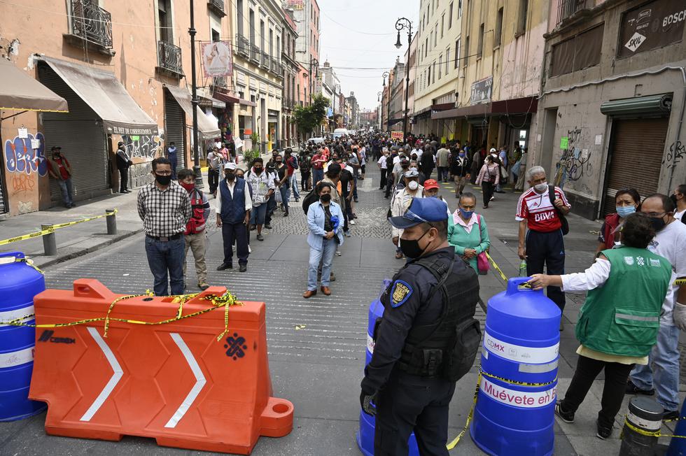La policía y los trabajadores del Gobierno de la ciudad se encuentran en un control peatonal que limita el acceso en grupos de 20 personas para ingresar al centro de la Ciudad de México. (Foto: ALFREDO ESTRELLA / AFP)