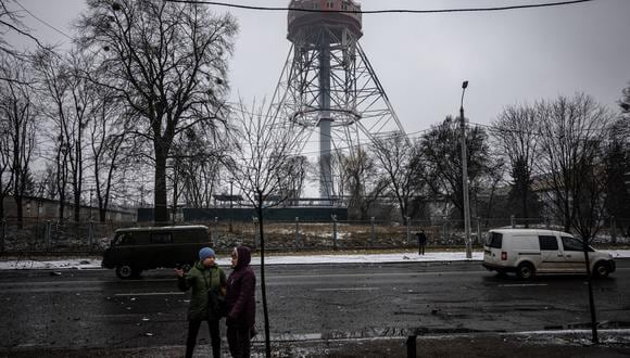 Dos mujeres hablan entre sí en el sitio del ataque aéreo de ayer que golpeó la principal torre de televisión de Kiev el 2 de marzo de 2022. (Foto referencial: Dimitar DILKOFF / AFP)