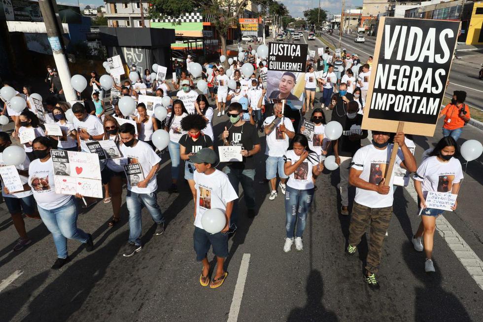 La marcha, que reunió a unas 250 personas, contó con numerosos carteles de denuncia al racismo y contra la violencia policial. Amigos del adolescente, identificado como Guilherme Silva Guedes, caminaron en silencio portando velas en señal de luto. (EFE/Leo Barrilari).