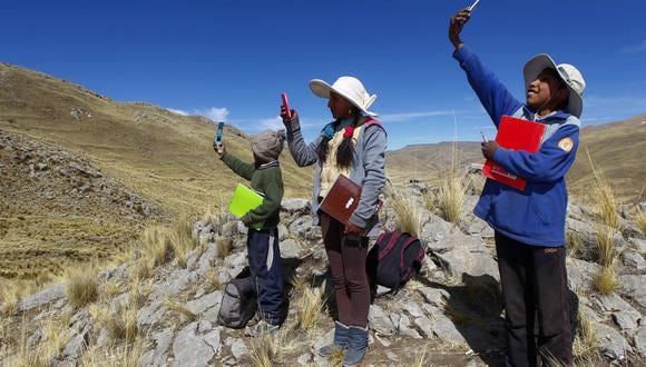 Niños buscan señal en la cima de una colina para asistir a sus clases virtuales durante la pandemia, cerca de su casa en la comunidad de Conaviri, distrito de Manazo, cerca del lago Titicaca y la frontera con Bolivia. (Foto: Carlos Mamani / AFP)