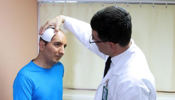 El cirujano maxilofacial Miguel Ángel González de Santiago, explica aVíctor Miguel Hernández Maldonado, el proceso de reconstrucción de cráneo que le fue practicada. (Foto: EFE)