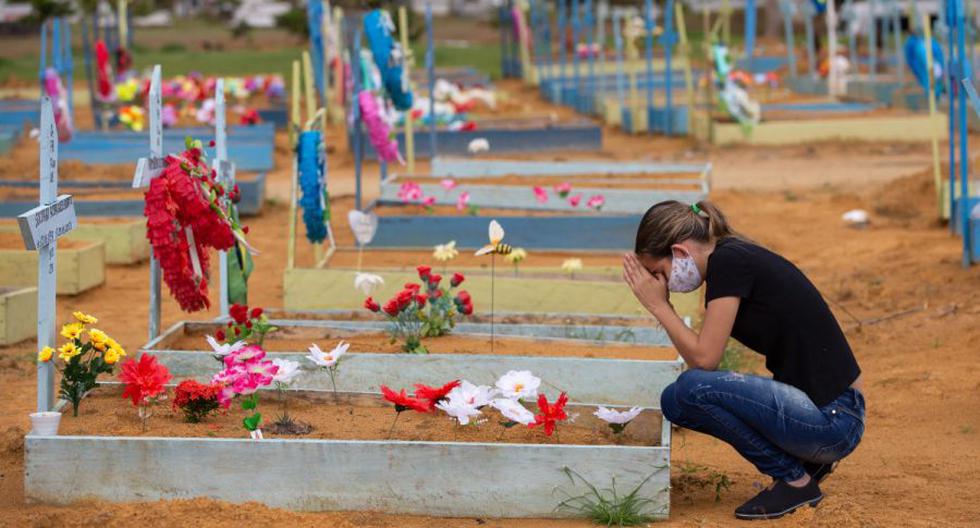 Una mujer se pone en cuclillas junto a una tumba en el cementerio de Nossa Senhora Aparecida el Día de la Madre, en Manaus, estado de Amazonas, Brasil, el 9 de mayo de 2021. (AFP / Michael DANTAS).